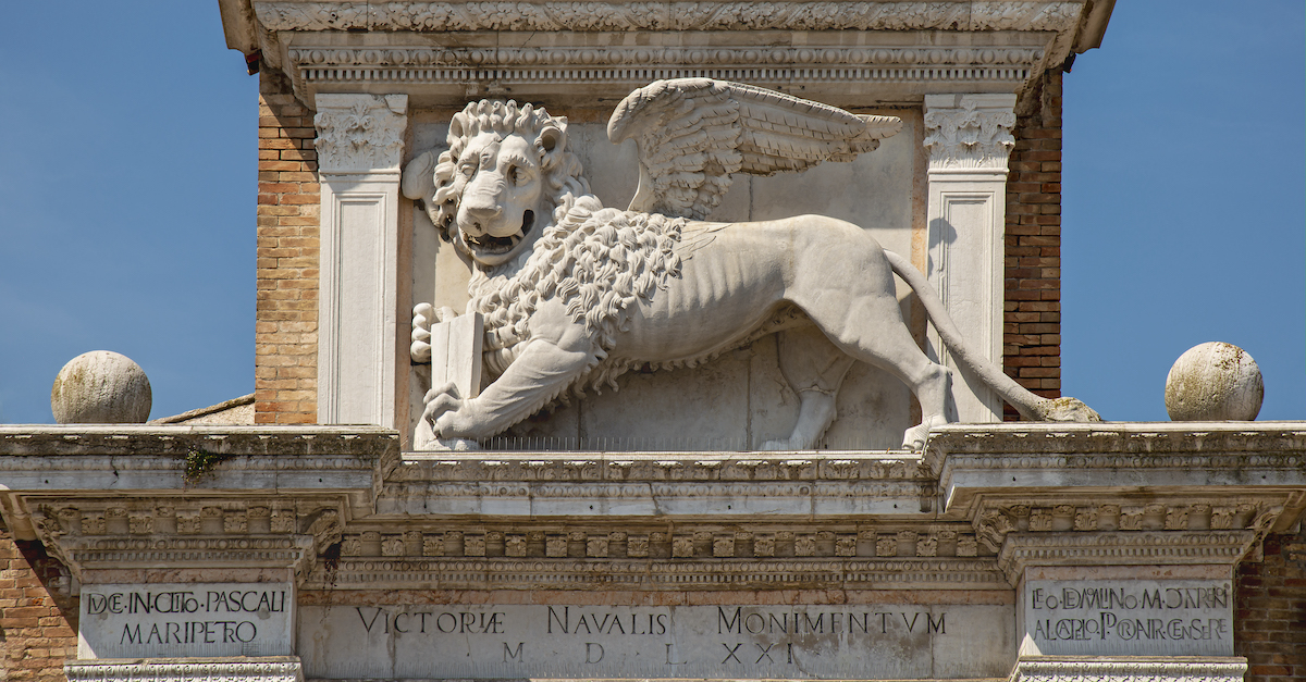 A stone Lion of Saint Mark from the pediment of the Arsenale di Venezia, holding a closed book in its in paws.